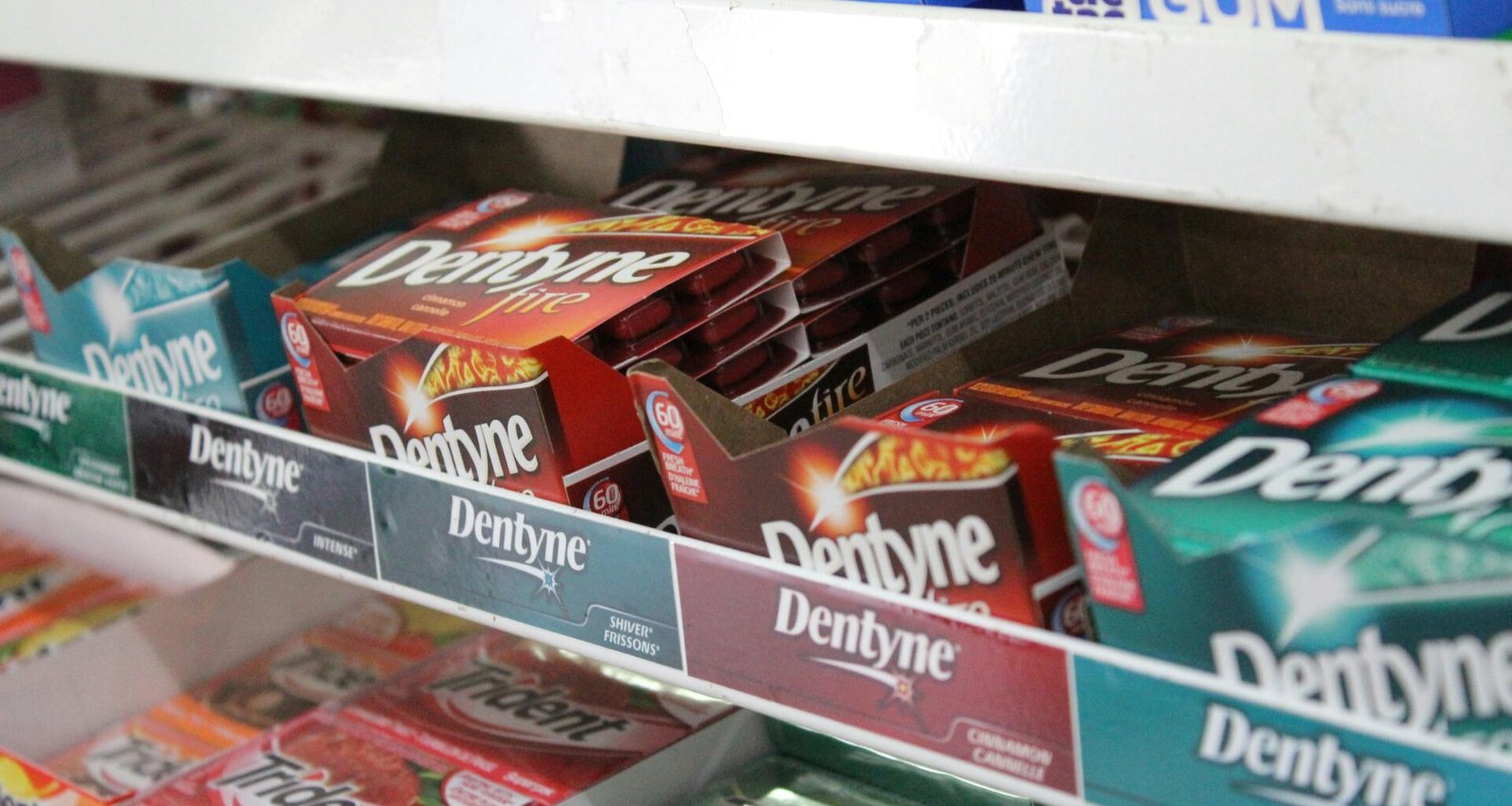 Ein KitKat Schokoriegel liegt auf einem weißen Regal. Klare Präsentation des Produkts, Fokus auf Verpackung und Form.