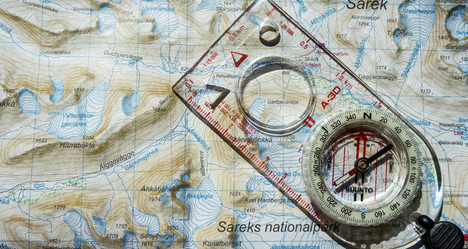 Ein transparenter Kompass mit weißem Lineal liegt auf einer detaillierten Kartenillustration als Symbol für präzise Planung.