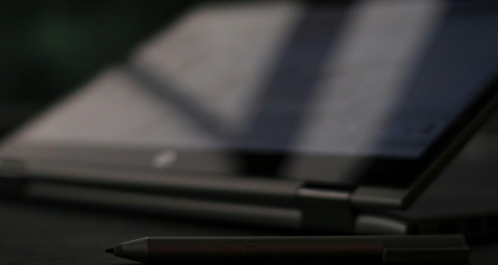 Schwarzer und silberner Klickkugelschreiber liegt auf einem hellen Untergrund, Fokus auf die Spitze des Stifts