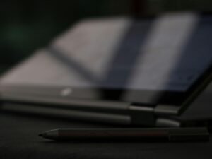 Schwarzer und silberner Klickkugelschreiber liegt auf einem hellen Untergrund, Fokus auf die Spitze des Stifts