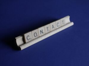 Scrabble-Steine formen das Wort Contact und symbolisieren die Bedeutung von Kommunikation im digitalen Zeitalter