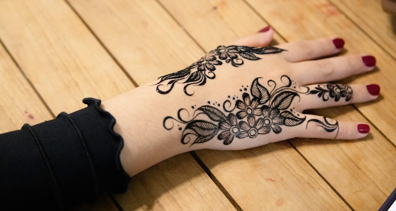 Detailliertes florales Henna-Muster auf einer Hand mit feinen Linien und traditionellen Ornamenten
