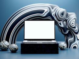 Laptop auf einem Podest, umgeben von abstrakten Skulpturen und sphärischer Kunst, als Symbol für modernes Technikdesign.