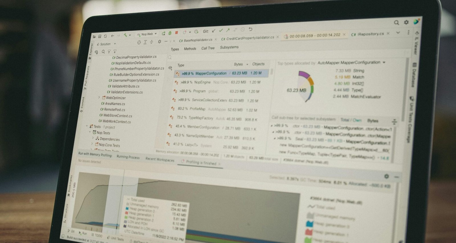 Laptopbildschirm mit geöffnetem Code-Editor und daneben angezeigten Datencharts auf dem Display im Büro