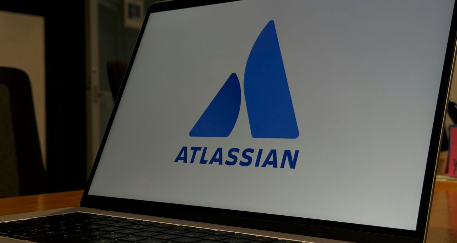 Laptop mit sichtbarem Atlassian-Logo auf dem Bildschirm, fotografiert als Symbol für digitale Teamarbeit und Projektmanagement-Software