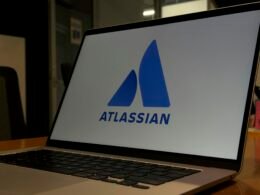 Ein aufgeklappter Laptop präsentiert groß das Atlassian-Logo auf dem Display, ideal für Artikel zur Teamarbeit und digitalen Tools.