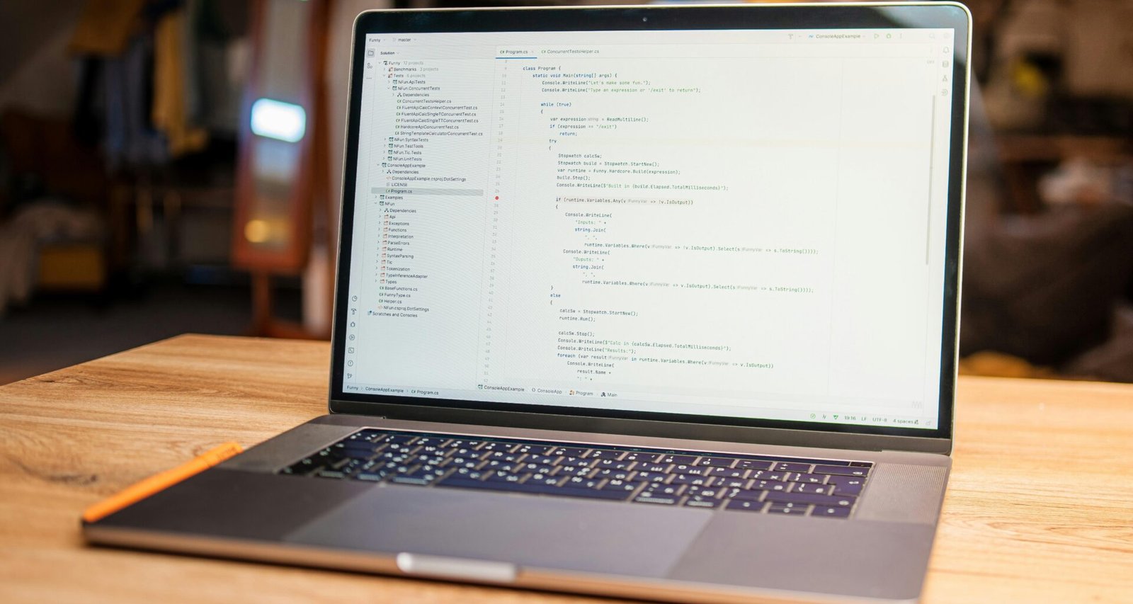 Laptop auf einem Tisch, auf dessen Bildschirm mehrere Zeilen Programmiercode angezeigt werden