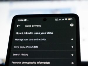 Smartphone zeigt LinkedIn-Datenschutzeinstellungen auf dem Bildschirm, Fokus auf Datenschutz und Privatsphäre-Einstellungen.
