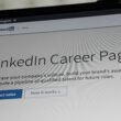 Laptop-Bildschirm mit geöffneter LinkedIn Karriere-Seiten-Oberfläche auf einem Schreibtisch, Fokus auf Benutzeroberfläche