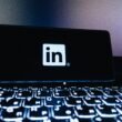 LinkedIn-Logo auf dem Bildschirm eines Smartphones, fotografiert vor neutralem Hintergrund