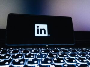 LinkedIn-Logo auf dem Bildschirm eines Smartphones, fotografiert vor neutralem Hintergrund