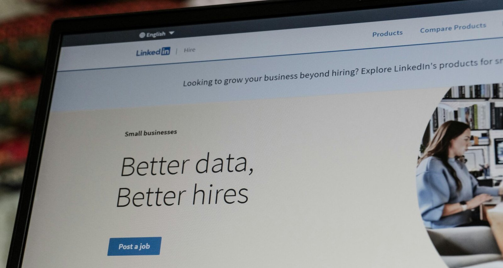 LinkedIn-Webseite mit dem Slogan 'Better Data, Better Hires' auf Laptopbildschirm im Büro dargestellt.