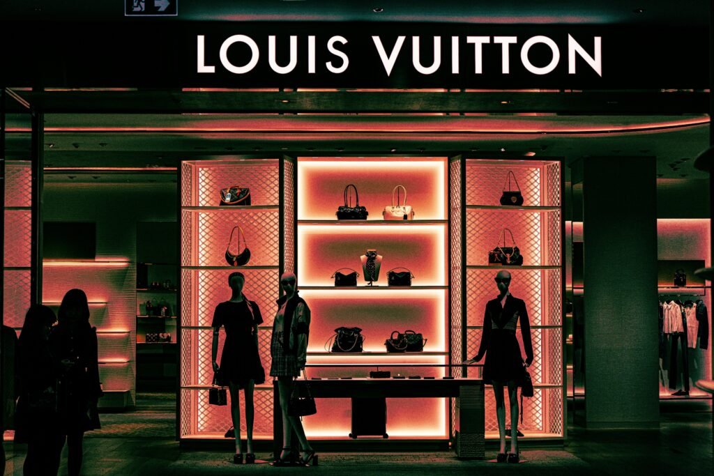 Innenansicht eines Louis Vuitton Stores mit Mannequins und Handtaschen in einem modernen Schaufenster-Design.