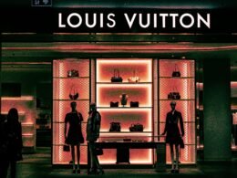 Innenansicht eines Louis Vuitton Stores mit Mannequins und Handtaschen in einem modernen Schaufenster-Design.