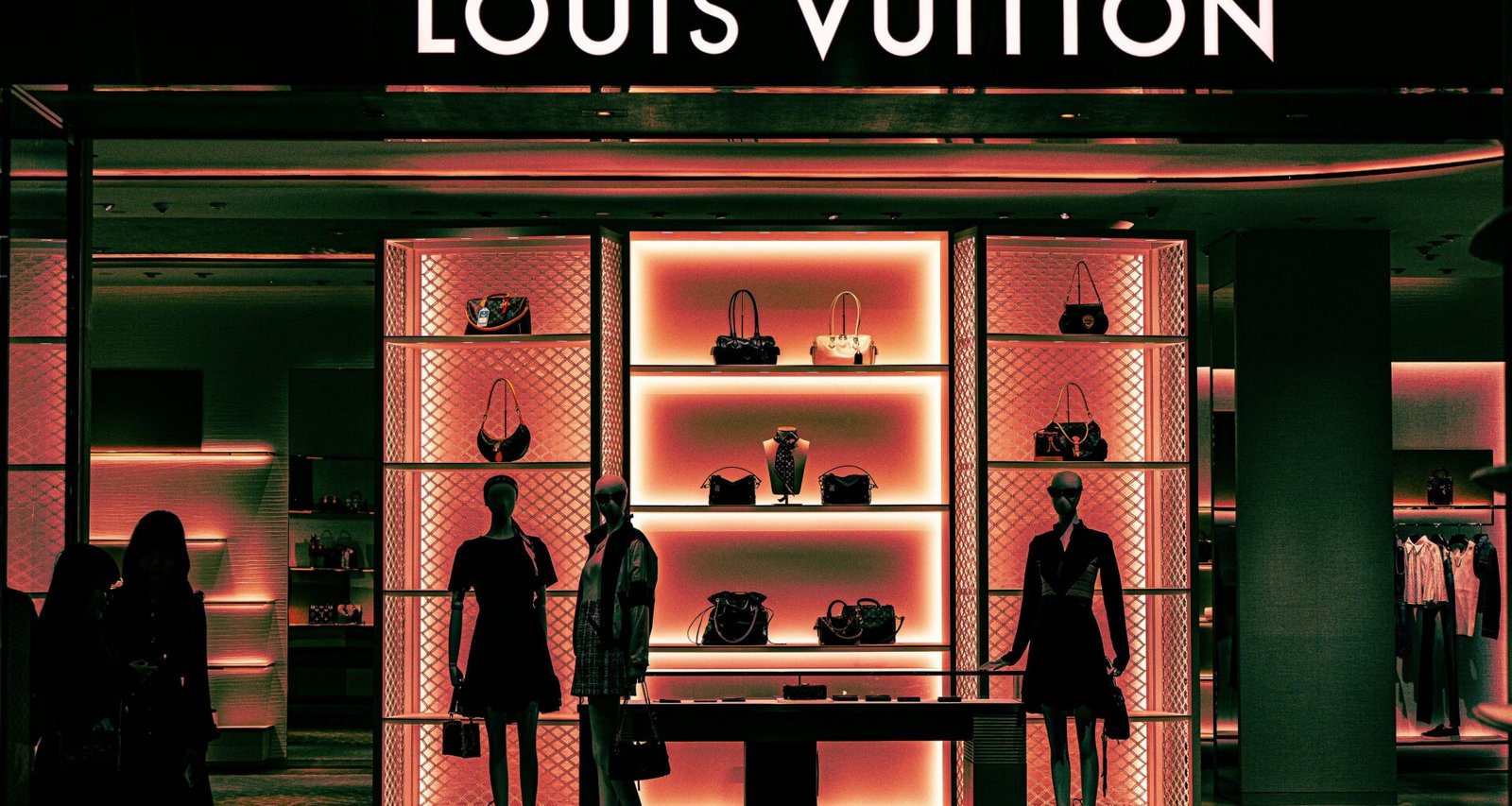 Schaufenster einer Louis Vuitton Boutique mit mehreren Mannequins und Designer-Handtaschen in moderner Präsentation