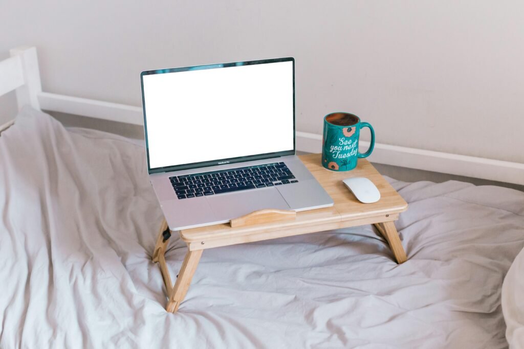 Ein MacBook Air steht geöffnet auf einem braunen Holztisch und zeigt einen typischen Arbeitsplatz im digitalen Zeitalter.