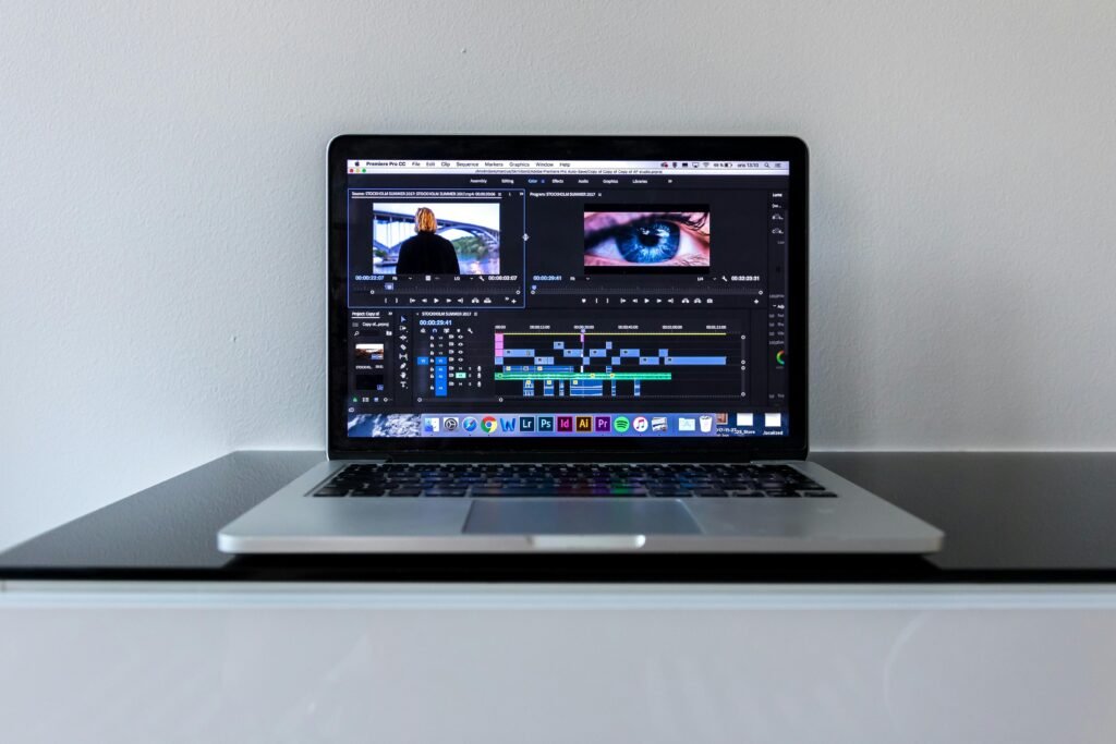 Ein MacBook Pro auf einem schwarzen Schreibtisch mit minimalistischem Setup, ideal für kreatives Arbeiten oder Online-Marketing Aufgaben.