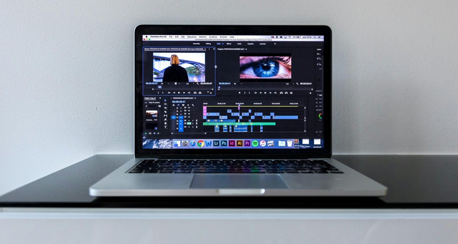 Ein MacBook Pro auf einem schwarzen Schreibtisch mit minimalistischem Setup, ideal für kreatives Arbeiten oder Online-Marketing Aufgaben.