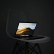 MacBook Pro, der auf einem schlichten Stuhl ruht – Symbol für mobiles und flexibles Arbeiten im digitalen Zeitalter