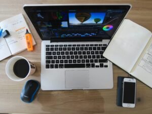 Ein eingeschaltetes MacBook Pro mit sichtbarem Bildschirm, das auf einem Tisch verwendet wird.