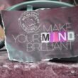Nahaufnahme einer Notiz mit dem handgeschriebenen Text 'Make your mind brilliant' auf weißem Papier