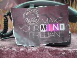 Nahaufnahme einer Notiz mit dem handgeschriebenen Text 'Make your mind brilliant' auf weißem Papier