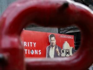 Ein Mann ist auf einem roten Werbeplakat im Stadtgebiet abgebildet, das moderne Werbemaßnahmen illustriert.