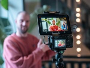 Mann filmt einen Videocall mit einer Kamera für professionelle Online-Meetings in modernem Umfeld