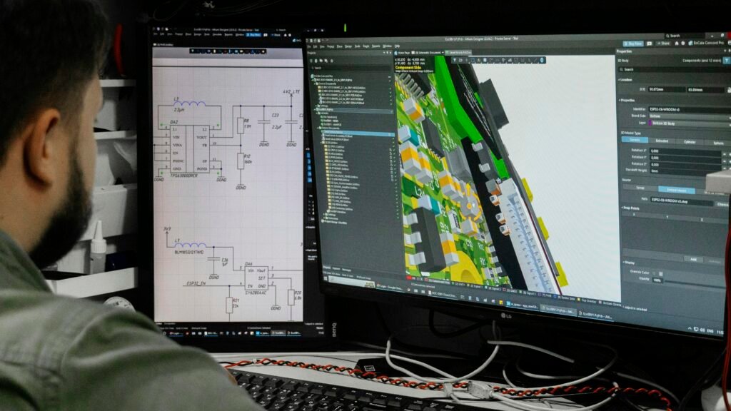 Mann sitzt am Arbeitsplatz und betrachtet eine digitale Schaltplanzeichnung auf einem Computerbildschirm