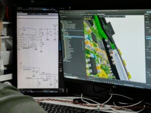 Mann sitzt vor Computer und analysiert ein Schaltplandesign auf dem Bildschirm, um elektronische Komponenten zu überprüfen