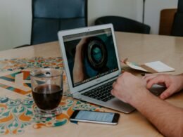 Mann sitzt an einem Schreibtisch und arbeitet am Laptop Computer, eingerichtet im modernen Arbeitsumfeld