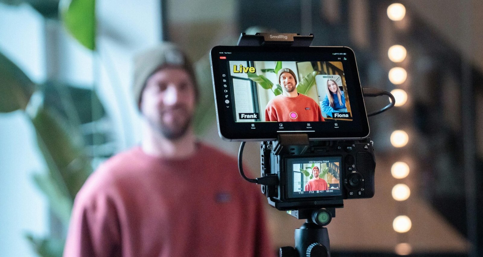 Mann filmt ein Video mit professioneller Kamera und Monitor bei der Arbeit in einem modernen Studio.