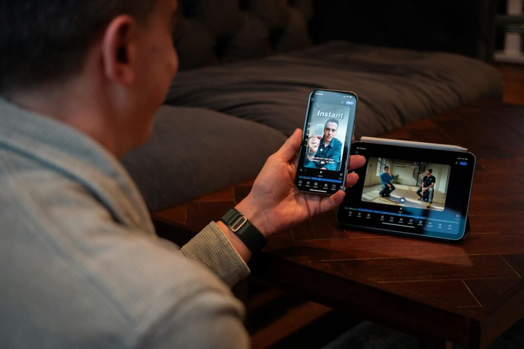 Ein Mann hält ein Smartphone in der Hand und schaut sich ein Video auf dem Bildschirm an, Alltagsszene digitaler Mediennutzung.