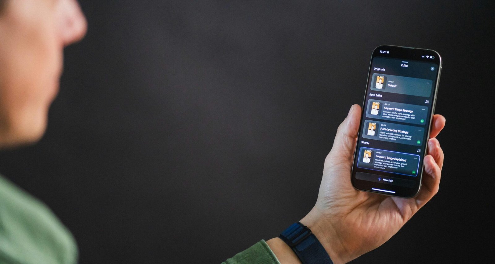 Ein Mann hält ein Smartphone in der Hand und betrachtet das Display mit einer modernen App-Oberfläche.