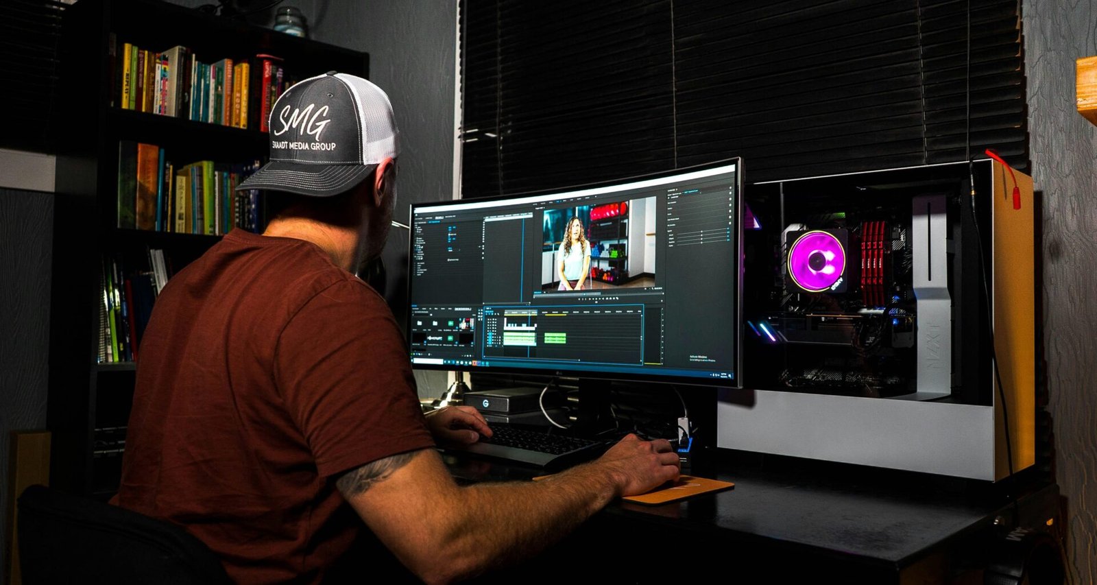 Mann in rotem T-Shirt sitzt an einem Computerarbeitsplatz in einem modernen Büro