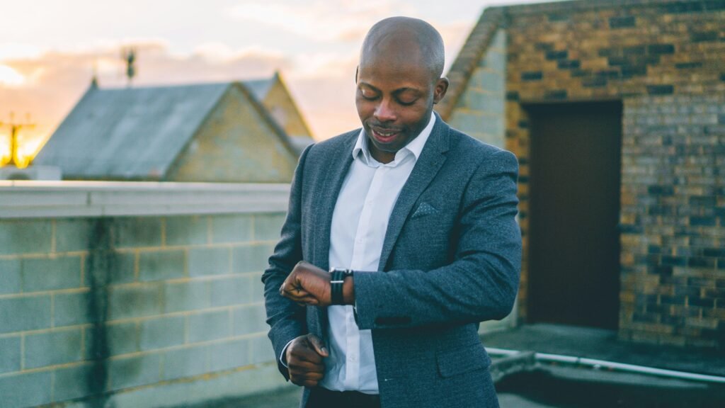 Ein Mann im grauen Anzug hält ein schwarzes Smartphone in der Hand und nutzt mobile Technologien im Büroalltag.