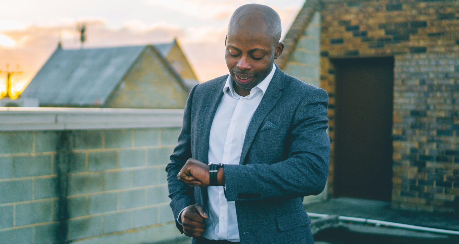 Ein Mann im grauen Anzug hält ein schwarzes Smartphone in der Hand und nutzt mobile Technologien im Büroalltag.