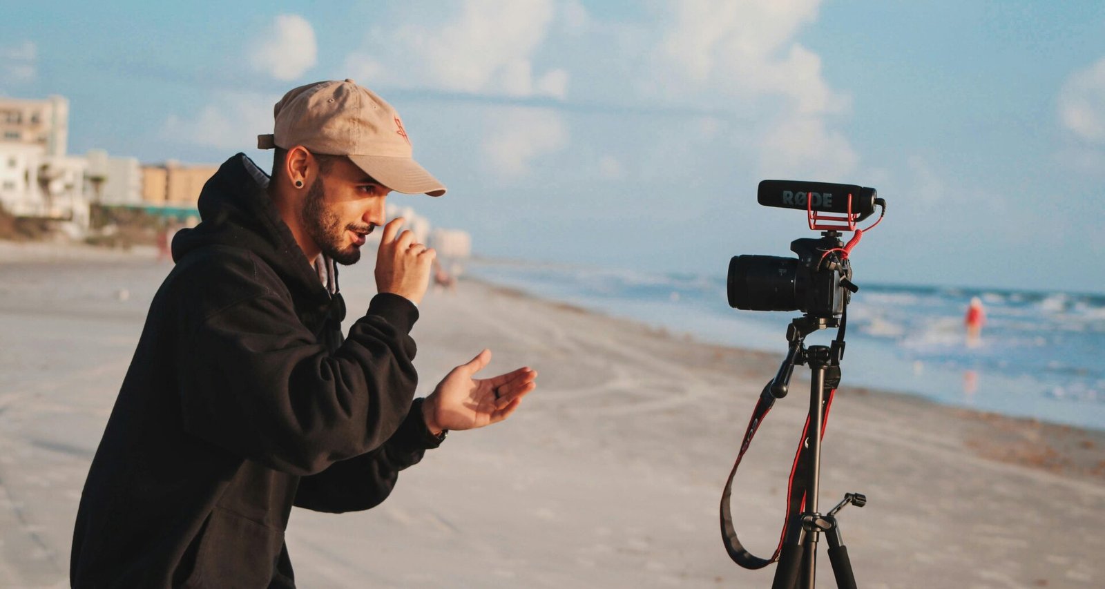 Mann in schwarzer Jacke hält eine Kamera in der Hand und fotografiert im Freien bei Tageslicht