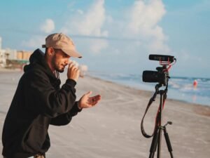 Mann in schwarzer Jacke hält eine Kamera in der Hand und fotografiert im Freien bei Tageslicht