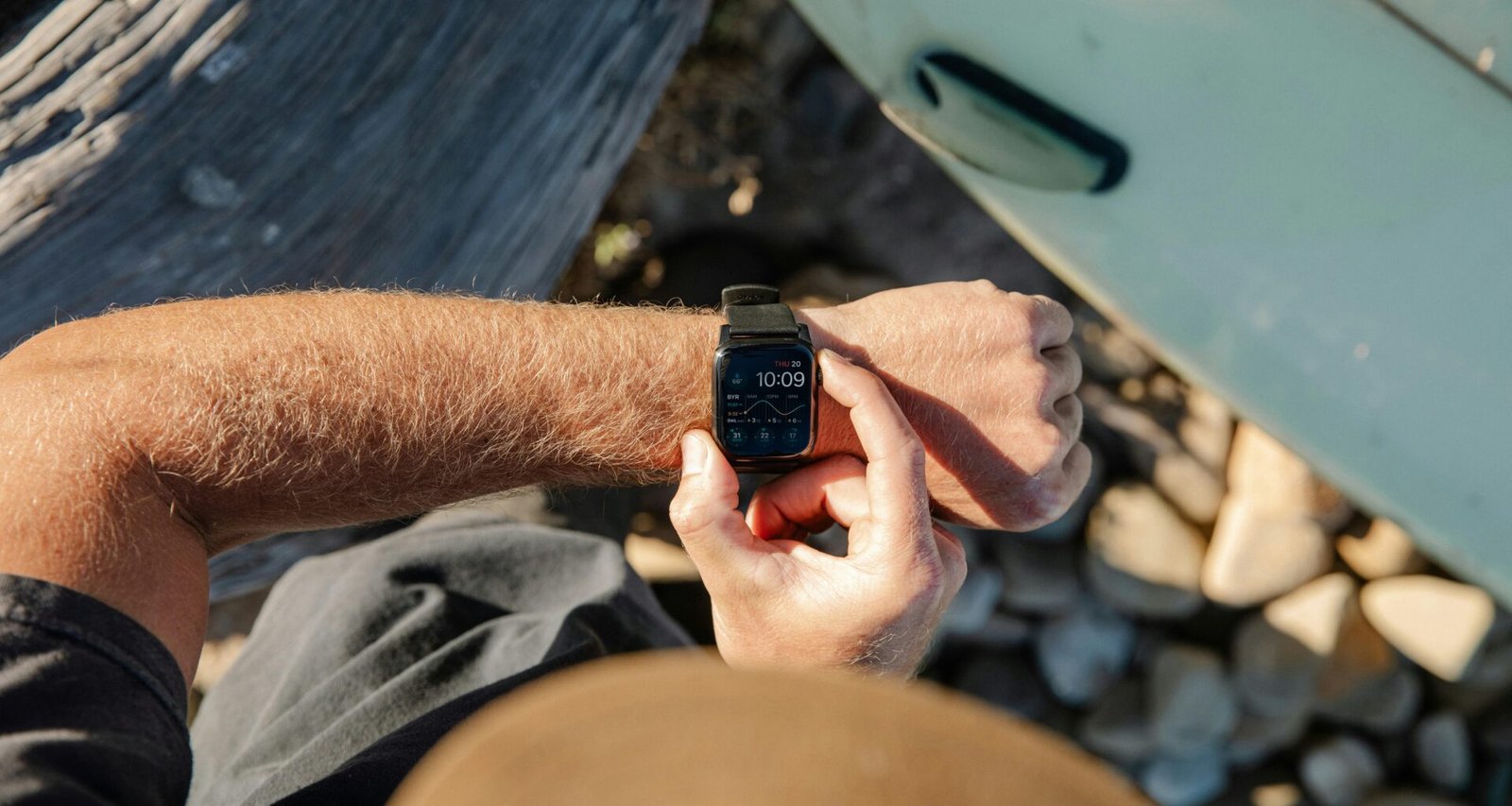 Mann im Freien sieht auf seine Armbanduhr, Nahaufnahme des Handgelenks mit klar erkennbarem Zifferblatt