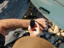 Mann im Freien sieht auf seine Armbanduhr, Nahaufnahme des Handgelenks mit klar erkennbarem Zifferblatt