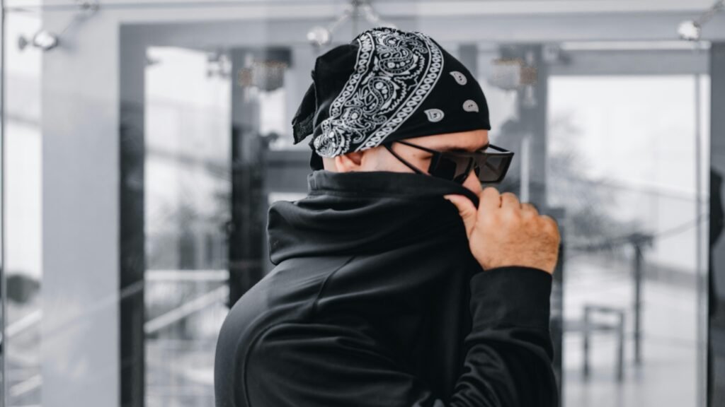 Mann mit Bandana und Sonnenbrille, der sein Gesicht teilweise verdeckt, Symbol für digitale Anonymität