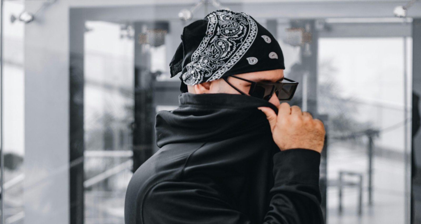 Mann mit Bandana und Sonnenbrille, der sein Gesicht teilweise verdeckt, Symbol für digitale Anonymität