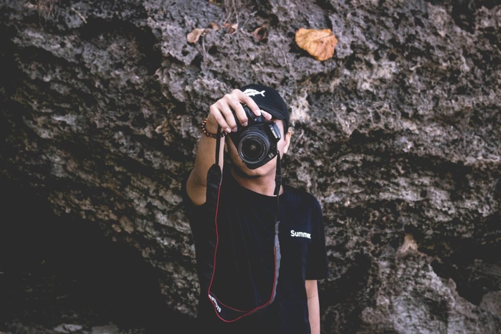 Ein Mann hält eine professionelle DSLR-Kamera in den Händen und steht bereit zum Fotografieren.