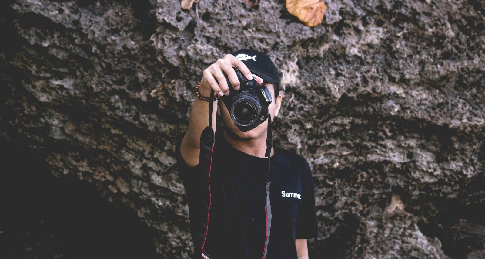 Ein Mann hält eine professionelle DSLR-Kamera in den Händen und steht bereit zum Fotografieren.