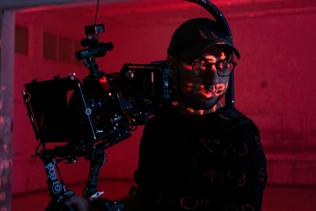 Ein Mann hält eine professionelle Videokamera in den Händen und richtet sie für Aufnahmen aus