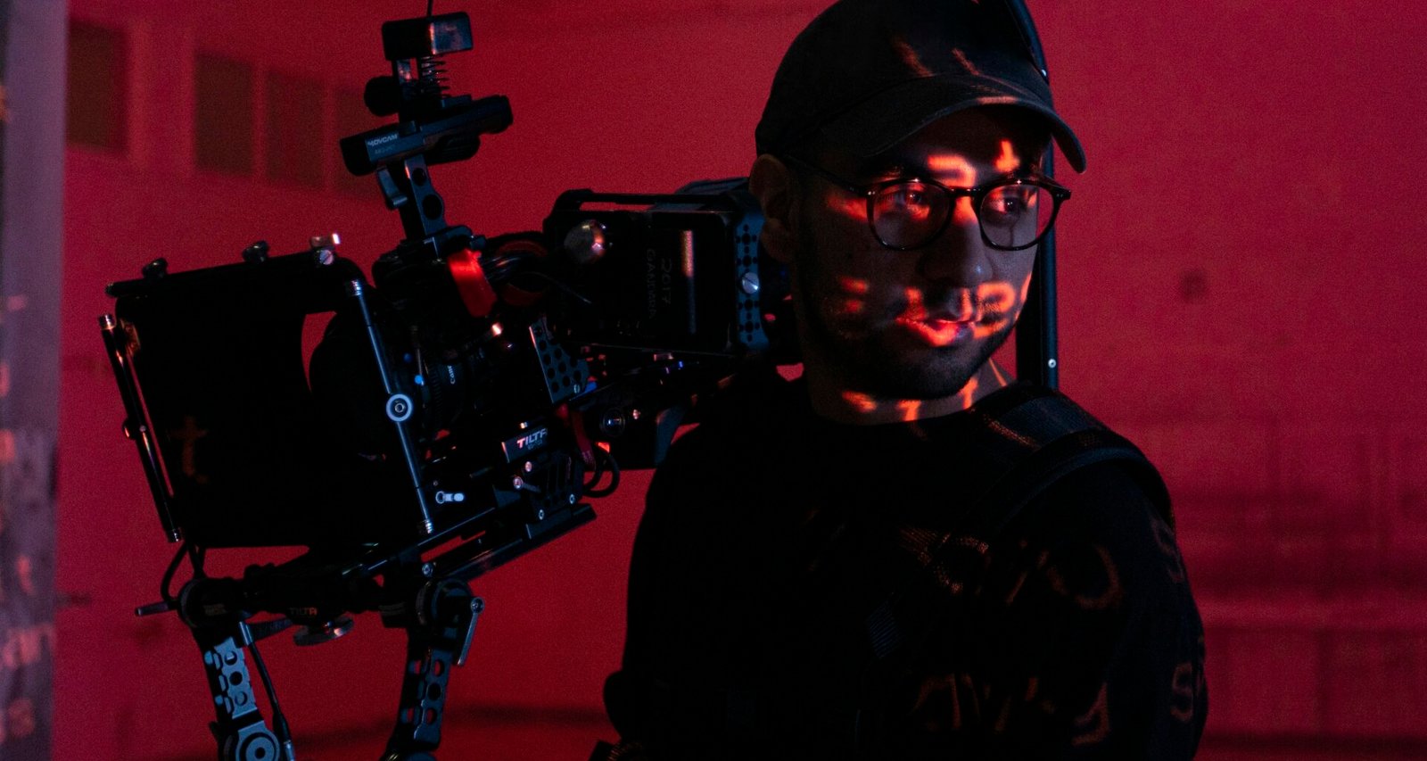 Ein Mann hält eine professionelle Videokamera in den Händen und richtet sie für Aufnahmen aus