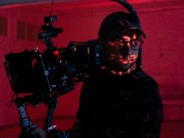 Ein Mann steht mit einer modernen Videokamera in den Händen und ist bereit für Filmaufnahmen.