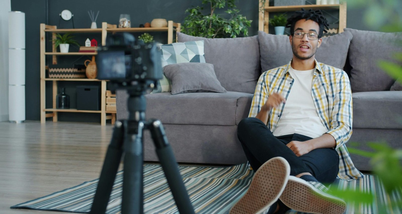 Ein Mann sitzt zu Hause und nimmt sich selbst mit einer Digitalkamera auf, um hochwertige Videos zu produzieren.