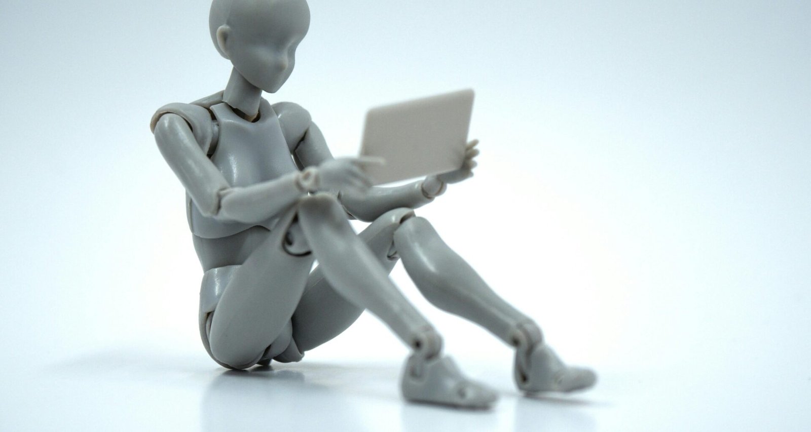 Puppe hält ein Tablet und interagiert mit der digitalen Oberfläche, Fokus auf Technologie-Nutzung im Alltag